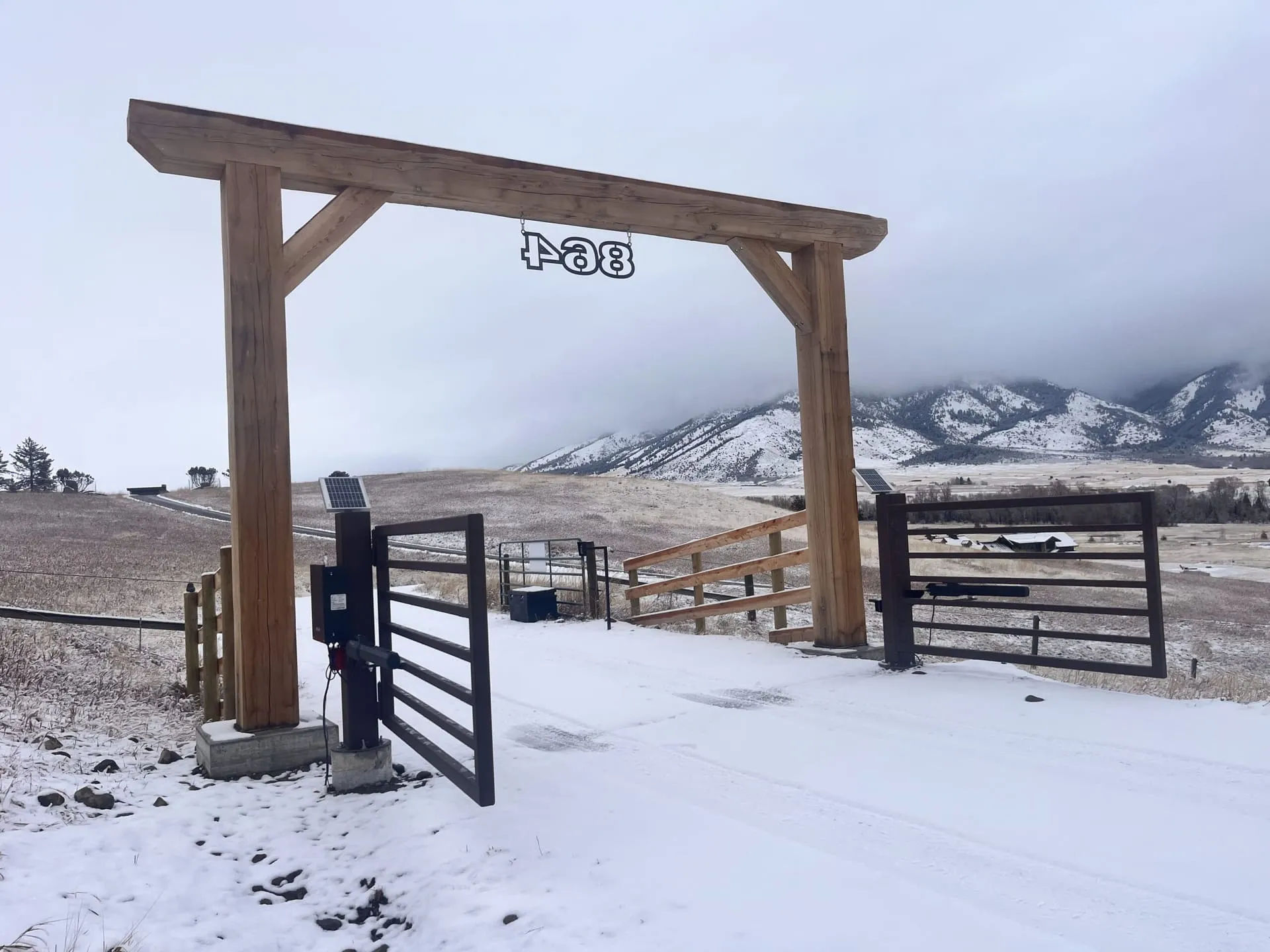 Automatic steel entry gate with timber archway near Livingston