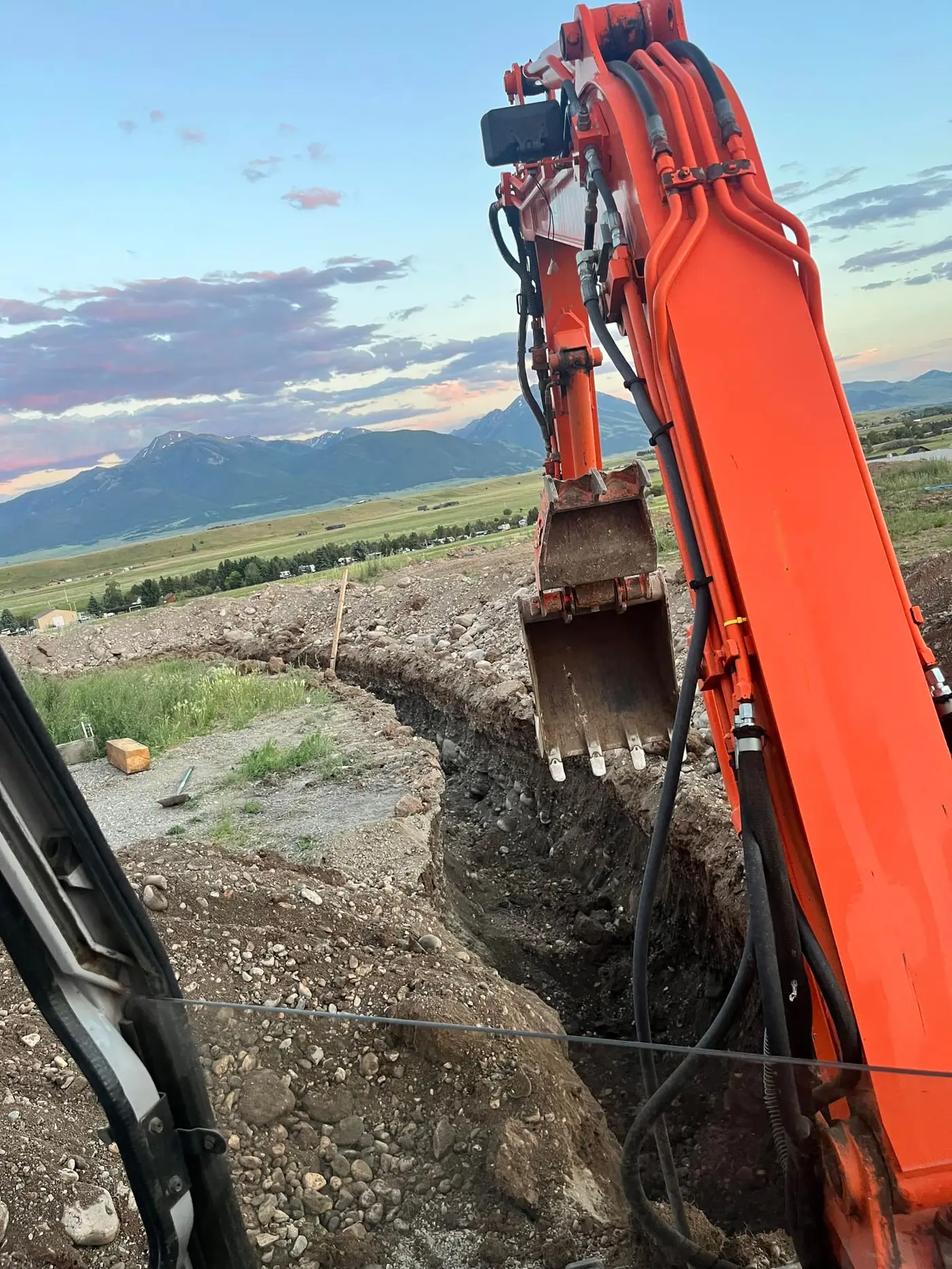 Excavator opening a trench on a Montana property