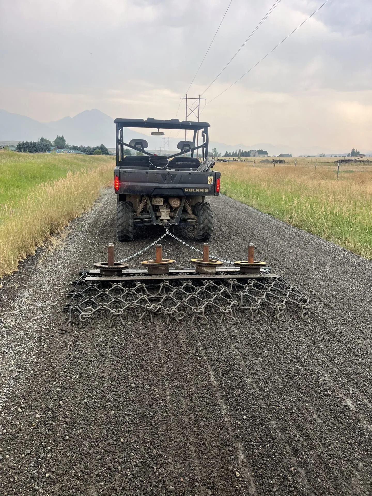 Grooming and grading a gravel ranch road surface in Montana
