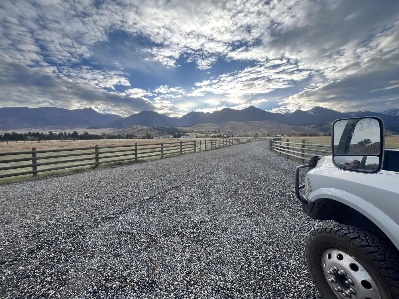 A crowned gravel ranch road sweeping toward the mountains in Paradise Valley, Montana