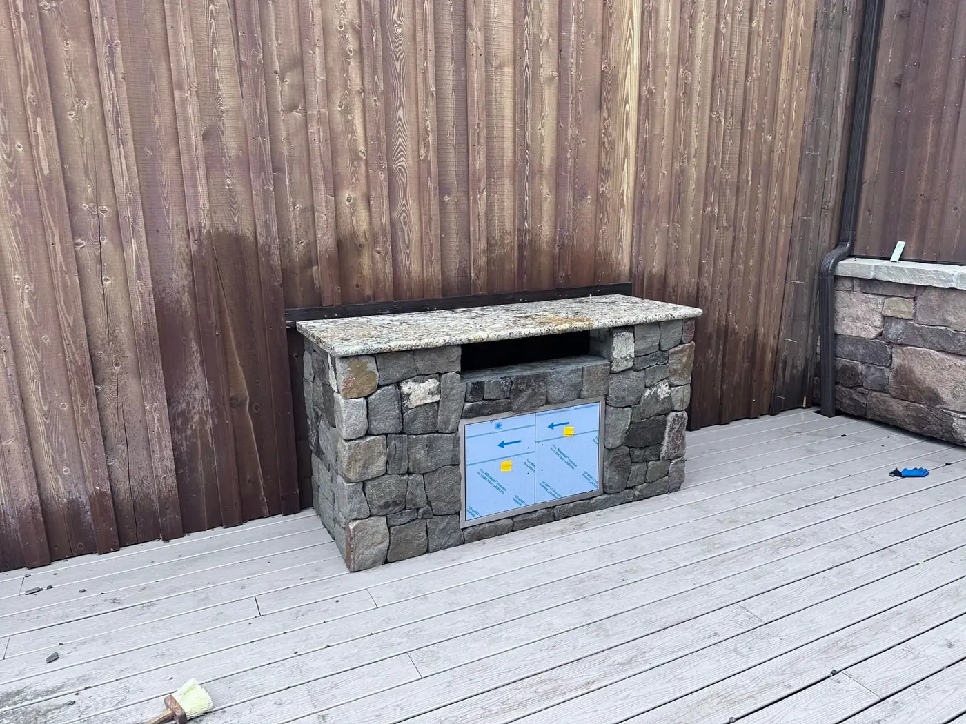 Stone veneer being applied to the grill island