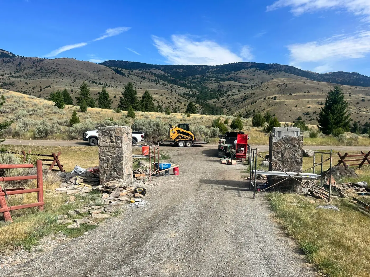 Stone entrance columns under construction at a Montana ranch driveway